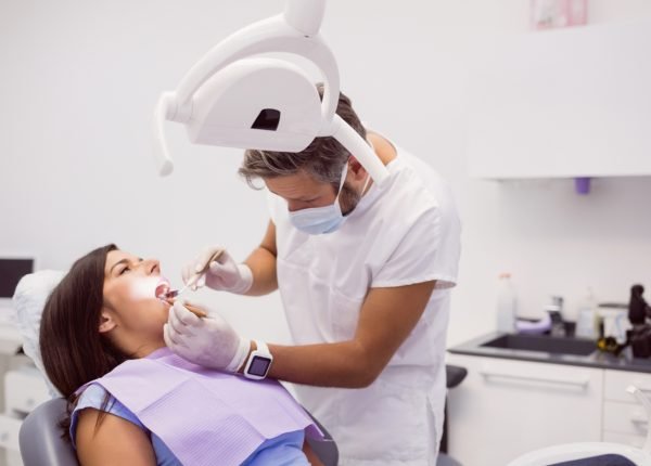 dentist-examining-female-patient-teeth